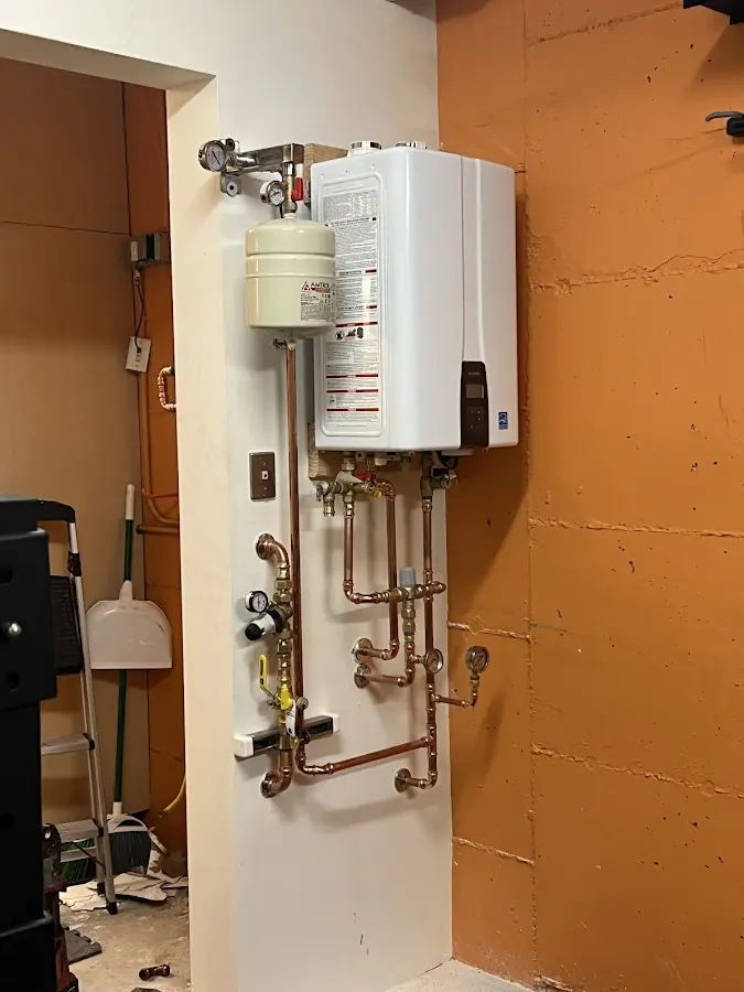 Plumbing technician inspecting water heater connections in Lower Southampton